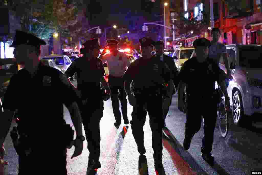 Police officers patrol a street while demonstrators take part in a march in support of the protests against the killing of Michael Brown, New York City, Aug. 20, 2014.