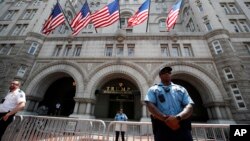 FILE - Law enforcement officers stand guard in front of the Trump Hotel in Washington, June 30, 2018.