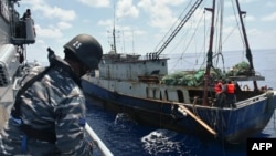 KRI Imam Bonjol-363 (kiri) menahan kapal nelayan China di perairan Natuna, 21 Juni 2016. (Foto: TNI AL via AFP)