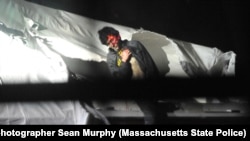 An injured Dzhokhar Tsarnaev emerges from the boat where he'd been hiding during the police manhunt for him, in Watertown, Massachusetts, April 19, 2013.