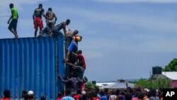 Residents overtake a truck loaded with relief supplies in Vye Terre, Haiti, Aug. 20, 2021. Private aid and shipments from the U.S. government and others were arriving in the country's southwestern peninsula, which was hit by a quake Aug. 14.