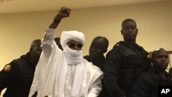 L'ancien dictateur du Tchad Hissène Habré lève la main pendant la procédure judiciaire à Dakar, Sénégal, 30 mai 2016. 
