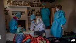 Health workers talk to Khatija, an elderly tribal woman, to persuade her to get the COVID-19 vaccine in Doodkulan village south of Srinagar, Indian-controlled Kashmir, June 5, 2021.