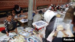 Vendors sell pictures of the royal family, as the country prepares for the funeral of Cambodia's late King Norodom Sihanouk, near the Royal Palace in Phnom Penh, January 31, 2013. 