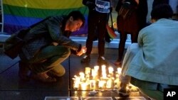 Un homme allume une bougie après la fusillade à Orlando, à Paris, France, 12 juin 2016.