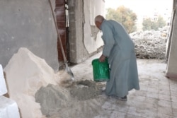 Ahmed Hashem, 60, patches up an apartment that once housed foreign IS fighters before they were defeated in 2017, in Raqqa, Syria, Feb. 23, 2020. (Heather Murdock/VOA)