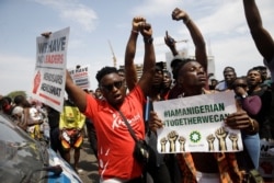 People hold banners as they demonstrate on the street to protest against police brutality in Lagos, Nigeria, Oct. 15, 2020.