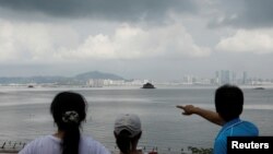 FILE - A tourist points China's Xiamen from a former military fort, ahead of the 60th anniversary of Second Taiwan Straits Crisis against China, on Lieyu island, Kinmen county, Taiwan, Aug. 20, 2018. 