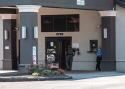FILE - A member of the Fulton County Sheriff's Office, center, walks into the Comfort Inn Sandy Springs - Perimeter hotel, where Iran set up a station for its citizens to vote in its presidential election, June 18, 2021, in Atlanta.