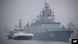 Sebuah kapal tunda mengawal kapal fregat Rusia Laksamana Gorshkov saat bersiap berlabuh di pelabuhan Qingdao di Provinsi Shandong, China timur (foto: dok). China dan Rusia memulai latihan angkatan laut bersama. 