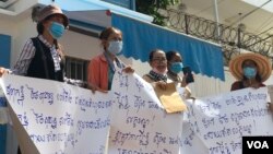 រូបឯកសារ៖ ក្រុមអ្នកតវ៉ា​លើក​បដានៅ​មុខ​ការិយាល័យ​ឧត្តមស្នង​ការ​អង្គការ​សហប្រជាជាតិទទួលបន្ទុក​សិទ្ធិមនុស្ស​នៅកម្ពុជា​ ថ្ងៃទី​១៩​ ខែ​មិថុនា​ ឆ្នាំ​២០២០ ស្នើឲ្យ​តុលាការ​ទម្លាក់​បទចោទ​ប្រកាន់​សាច់​ញាតិ​របស់​ពួកគេ​ ដែល​ជា​​អតីត​មន្ត្រី​គណបក្សប្រឆាំង​​។ (ហ៊ុល រស្មី​/វីអូអេ)