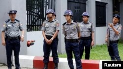FILE - Police officers stand guard at a building in Yangon, Myanmar, Aug. 9, 2019.