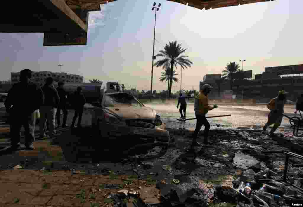 People gather at the site of car bomb attack in Baghdad, January 15, 2014.