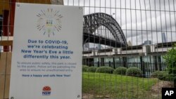 Papan peringatan Covid-19 dekat Sydney Harbour menjelang perayaan malam Tahun Baru di Sydney, Australia, Kamis, 31 Desember 2020. 