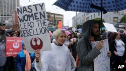 A woman holds a sign in a women's march during the first full day of Donald Trump's presidency in San Francisco, Jan. 21, 2017. 