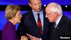 Democratic 2020 U.S. presidential candidates (L-R) Senator Elizabeth Warren (D-MA) speaks with Senator Bernie Sanders (I-VT) as billionaire activist Tom Steyer listens after the seventh Democratic 2020 presidential debate in Des Moines.