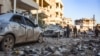 People check damage in a street following an airstrike by Syrian government forces in the town Maarrat Misrin, in Syria’s northwestern Idlib province, Feb. 25, 2020. 