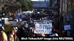 Para pengunjuk rasa berpawai di pusat kota menentang karantina wilayah di tengah wabah COVID-19 di Sydney, Australia, Sabtu, 2 Juli 2021. (Foto: Mick Tsikas/AAP Image via Reuters)