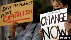 FILE - Demonstrators protest during a climate change strike in front of the St. Joseph Cathedral in Hanoi, Vietnam, Sept. 27, 2019. 