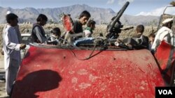 Warga Afghanistan mengelilingi mobil penduduk yang hancur akibat ledakan bom di Laghman, Afghanistan (12/11).