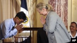 Secretary of State Hilary Rodham Clinton bows in response to Vannak Anan Prum of Cambodia, before presenting him with a plaque for his work to end human trafficking, during the release of the 2012 Trafficking in Persons Report at the State Department in 