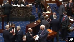 Arhiva - Republikanski senatori i osoblje Kongresa razgovaraju u sali za sednice u pauzi drugog suđnja za opoziv predsednika Donalda Trampa u Senatu, na Kapitolu, 13. februara 2021. (Senate Television via AP)