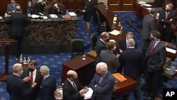 FILE - In this image from video, Republican senators and staff talk on the floor at the second impeachment trial of former President Donald Trump in the Senate, at the U.S. Capitol in Washington, Feb. 13, 2021. (Senate Television via AP)