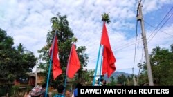 Demonstrators carry flags as they protest the military coup in a village in Launglon township, Myanmar, April 9, 2021. (Courtesy of Dawei Watch/via Reuters)