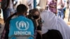 Akris Angelina Jolie, utusan khusus badan PBB untuk urusan pengungsi (UNHCR), berbincang-bincang dengan pengungsi Mali di kamp Goudebo, di utara Burkina Faso, dalam peringatan Hari Pengungsi Sedunia, Minggu, 20 Juni 2021. (Foto: Olympia de Maismont/AFP)