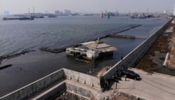 FILE - This view shows a sea wall used to keep sea water from flowing into Jakarta, July 27, 2019. Indonesia's president wants the speedy construction of the giant sea wall to save the low-lying capital of Jakarta from sinking under the sea.