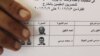 An Egyptian expatriate displays his ballot before casting his vote.