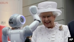 Ratu Elizabeth II dari Inggris tersenyum melihat sebuah robot kecil melambaikan tangan ke arahnya dalam resepsi di Technische Universitaet di Berlin, Jerman (24/6). 