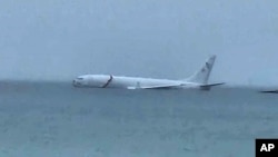 This photo provided by Diane Dircks shows a U.S. Navy plane that overshot a Marine base on Kaneohe Bay, Hawaii, Nov. 20, 2023. An official says all nine people aboard the plane have escaped injury. 