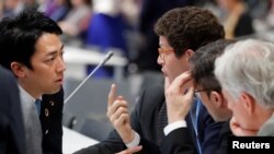 Japan's Environment Minister Shinjiro Koizumi talks with Brazil’s Environment Minister Ricardo Salles at the U.N. Climate Change Conference (COP25) in Madrid, Spain, Dec. 15, 2019. 