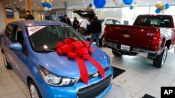FILE - People walk through the Taylor Chevrolet showroom in Taylor, Mich., Dec. 28, 2017. 