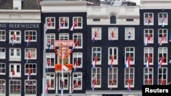 FILE - Dutch national flags hang from windows overlooking Central Station in Amsterdam, The Netherlands, April 28, 2013. Voters in the country where the modern European Union was born are now increasingly looking to reclaim some of their sovereign rights they feel the EU bureaucracy in Brussels has taken away from them.