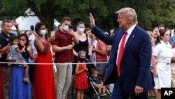 FILE - President Donald Trump greets visitors as he walks on the South Lawn of the White House during a "Salute to America" event, July 4, 2020.