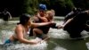 Venezuelan migrant Alvaro Calderini carries his niece across a river near Bajo Chiquito, Panama, after walking across the Darien Gap from Colombia on their way north to the United States, Nov. 9, 2024.