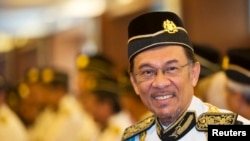 FILE - Malaysia's opposition leader Anwar Ibrahim smiles as he he arrives for the opening of the parliament sitting at Parliament House in Kuala Lumpur June 25, 2013.