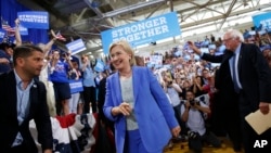 Democratic presidential candidate Hillary Clinton, followed by Sen. Bernie Sanders, I-Vt. arrives for a rally in Portsmouth, N.H., Tuesday, July 12, 2016. (AP Photo/Andrew Harnik)