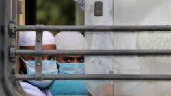 FILE - Indian Muslims wait in a bus to be taken to a coronavirus quarantine facility, in the Nizamuddin area of New Delhi, India, March 31, 2020.