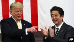 U.S. President Donald Trump, left, and Japan's Prime Minister Shinzo Abe react during delivering a speech to Japanese and U.S. troops as they aboard Japan Maritime Self-Defense Force's (JMSDF) helicopter carrier DDH-184 Kaga at JMSDF Yokosuka base in Yokosuka,Tuesday, May 28,2019