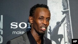 Barkhad Abdi poses for photographers as he walks the red carpet at a screening for the movie "Captain Phillips" at the Newseum in Washington, Oct. 2, 2013.