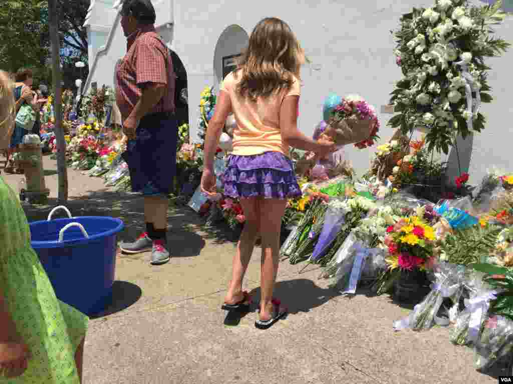 Children lay flowers outside of the Emanuel AME Church, Charleston, June 20, 2015. (Amanda Scott/VOA) 
