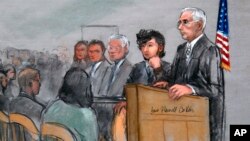 In this courtroom sketch, Boston Marathon bombing suspect Dzhokhar Tsarnaev, second from right, is depicted with his lawyers, left, beside U.S. District Judge George O'Toole Jr., right, as O'Toole addresses a pool of potential jurors in a jury assembly room at the federal courthouse in Boston, Jan. 5, 2015.