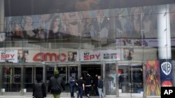People enter an AMC theater March 14, 2020, in Los Angeles. 