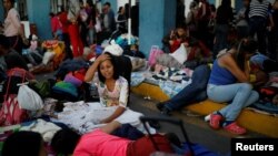 Venezuelan migrants start to wake up after spending the night at the Ecuadorian Peruvian border service center to get their documents processed and continue their journey, in the outskirts of Tumbes, Peru June 15, 2019. (REUTERS/Carlos Garcia Rawlins)