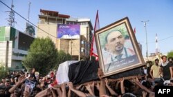 Para pelayat menyerukan slogan-slogan sambil menguzung peti jenazah aktivis anti-pemerintah Ehab al-Ouazni, saat prosesi pemakamannya di Kota Karbala, Minggu, 9 Mei 2021. Wazni tewas setelah ditembak orang tak dikenal di depan rmahnua.