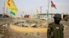FILE - A soldier of the Kurdish Democratic Party (KDP) patrols at a destroyed roundabout in the town of Snuny, close to Sinjar, northern Iraq, Jan. 29, 2015. The KDP has been using crossings at the Iraq-Syria border as a tool to exert political pressure on its historical rivals that dominate the Syrian Kurdish region.