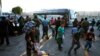 Sejumlah migran tampak menunggu di luar pusat penampungan migran di Jembatan Internasional 1, sebelum menaiki bus dari Nuevo Laredo menuju Monterrey, Meksiko, pada 16 Juli 2019. (Foto: AP/Marco Ugarte)